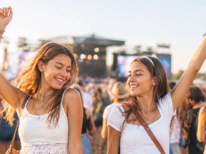 Two teenage girls enjoying pop music at a music festival